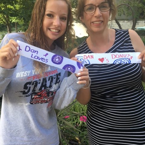 Mother and daughter holding banners of Dan's Donuts